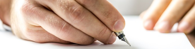 Man writing on a blank paper with ink pen.
